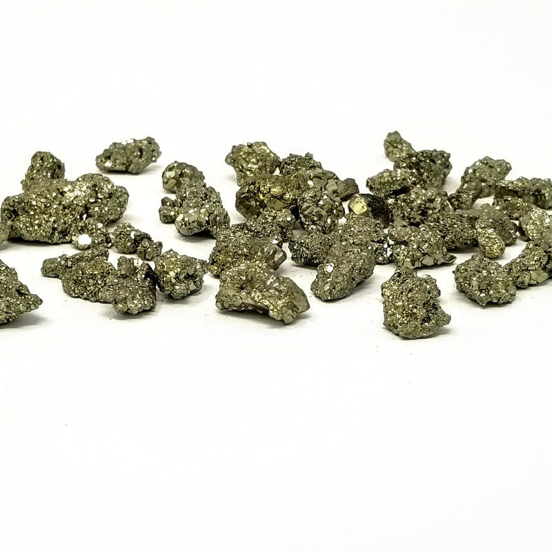 Raw Pyrite Clusters scattered about on a white background