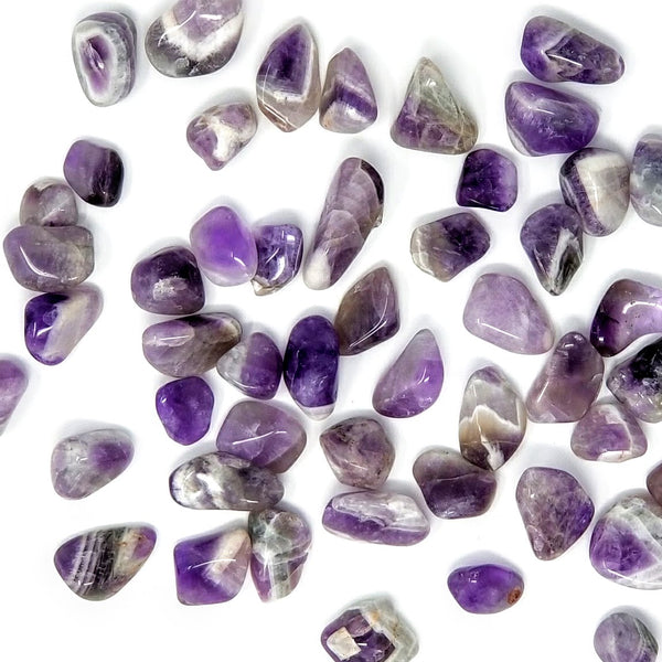 Chevron Amethyst Tumbled Stones scattered on a white background