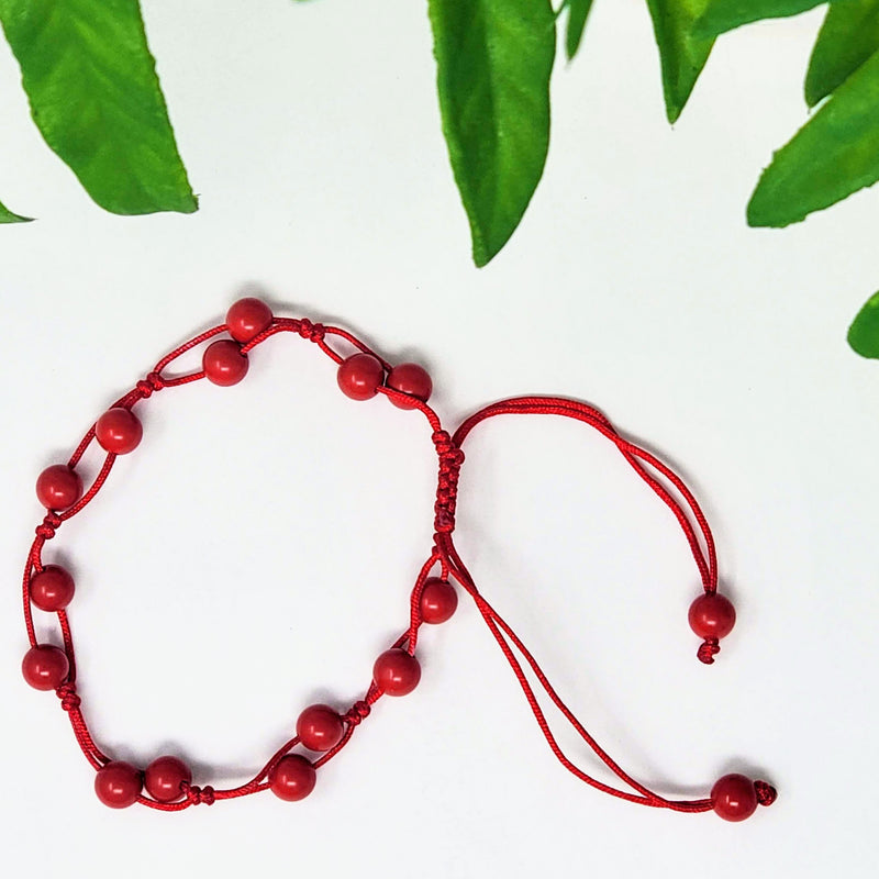 Adjustable round bead Coral bracelet on white background