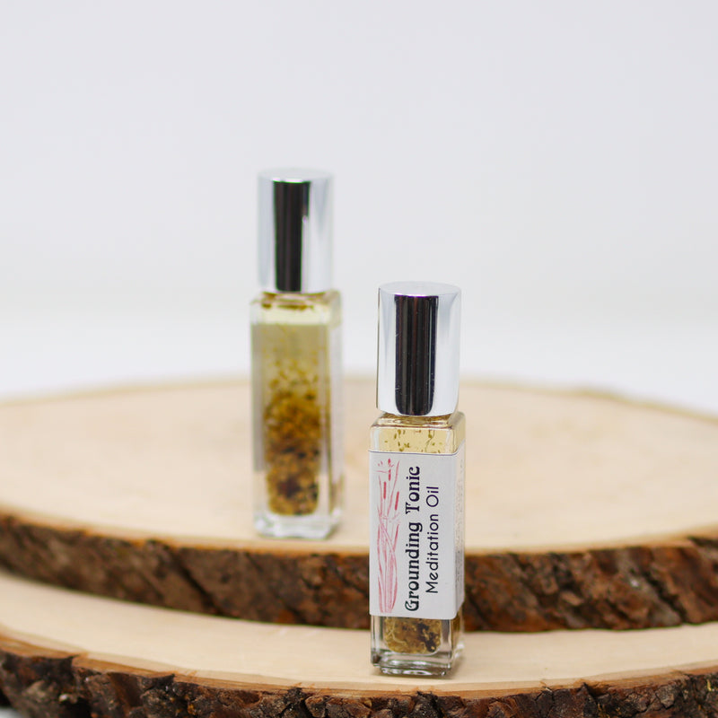 A front and back view of Grounding Tonic Anointing Oil on a white background