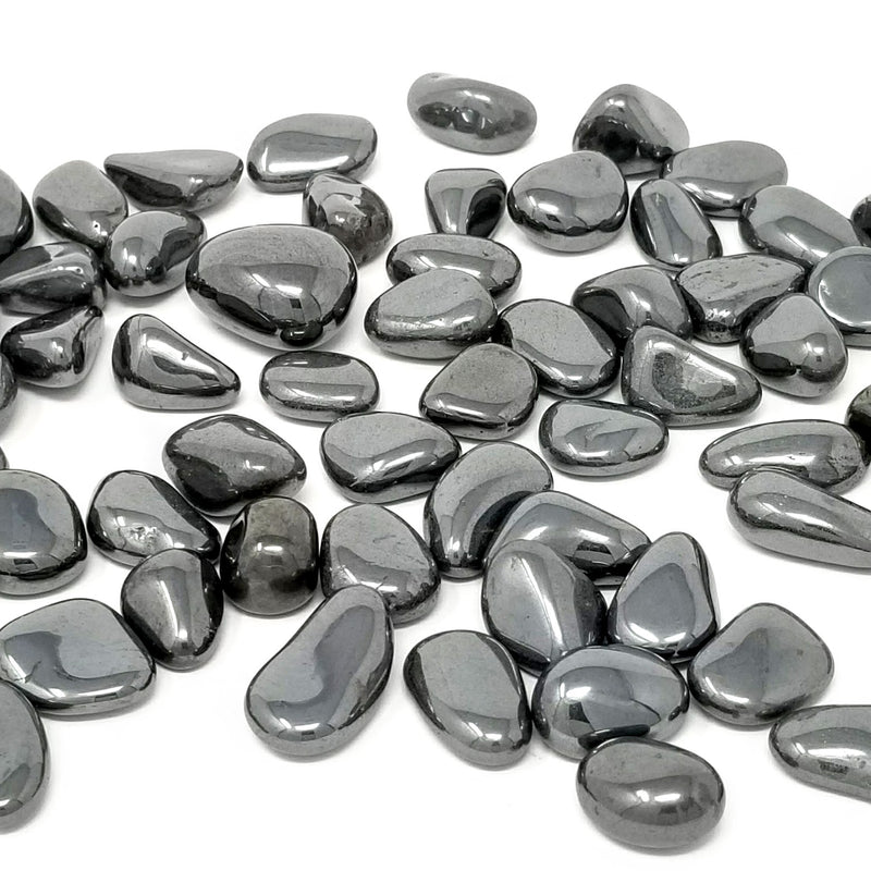 Hematite Tumbled Stones scattered on a white background