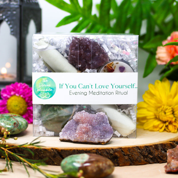 Stunning photo of our If You Can't Love Yourself... Evening Meditation Ritual with Pink Amethyst Clusters and Chrysoprase Palmstones in the foreground and fresh flowers next to a lit lantern in the background