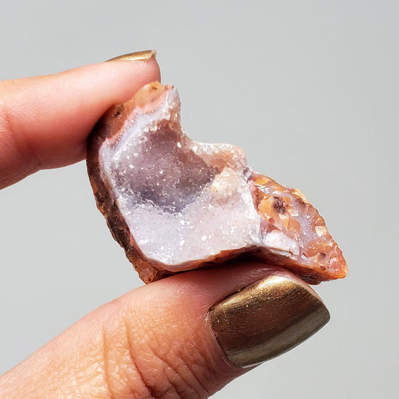 A hand holding up a Pink Amethyst Cluster
