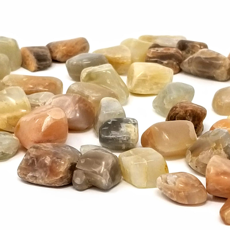Peach moonstone Tumbled Stones scattered on a white background