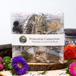 Front of Protection Connection Crystal Grid Ritual kit, surrounded by vibrant flowers 