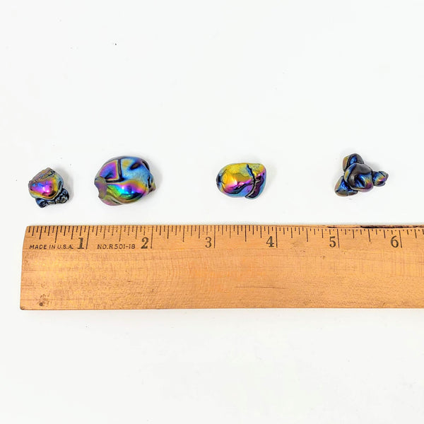 Rainbow Aura Fairy Stones lined up next to a ruler to show actual size of these stones
