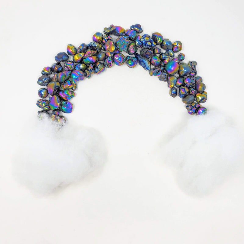 A magically fun display of Rainbow Aura Fairy Stones grouped together to form the shape of a rainbow, complete with "clouds" made of fluffy cotton at either end.  The only thing missing it a pot of gold!