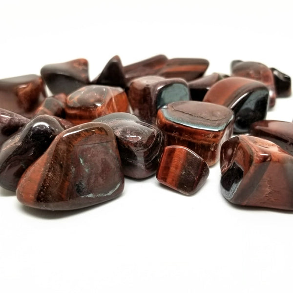 Red Tigers Eye Tumbled Stones scattered on a white background