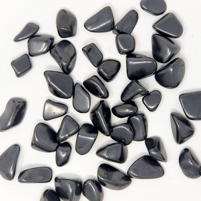 Shungite Tumbled Stones scattered across a white background
