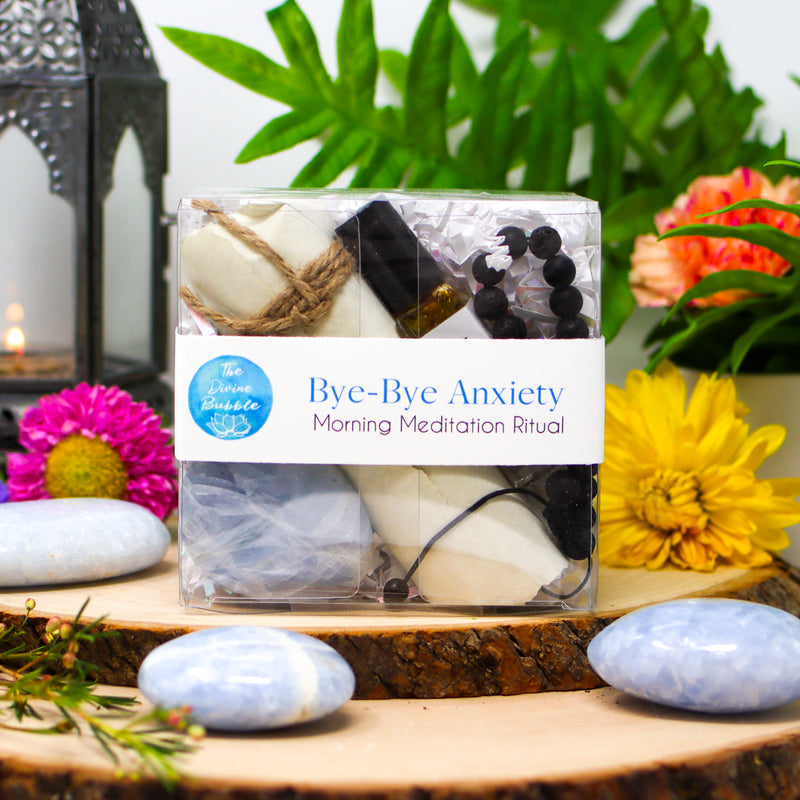 Bye-Bye Anxiety Morning Meditation Ritual kit surrounded by Blue Calcite palm stones and brightly colored flowers